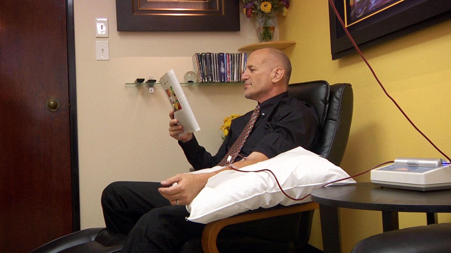 a man in a suit and tie tie tie sitting in a chair - Ozone IV Therapy AMA Skincare